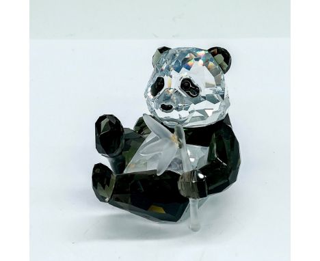 A clear and black crystal figure of a young panda bear munching on a frosted bamboo stalk. Swarovski marking. This item has i