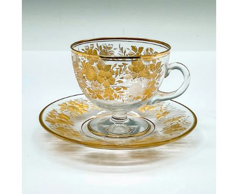 An elegant clear espresso cup and saucer with gilded floral pattern. Cup: 3.5"L x 2.75"W x 2.5"H. Saucer: 4.5"W x 0.5"H. Cond