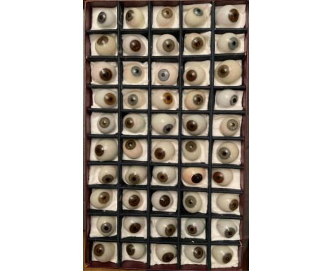 A boxed set of fifty vintage prosthetic glass eyes, Paris c.1930 by Henri Giron, various colours and sizes, in original subdi