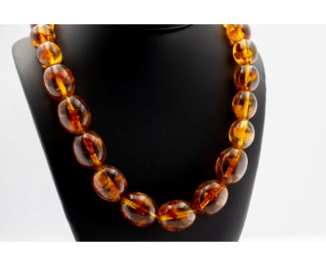 A vintage polished amber bead necklace, 38 graduated beads with various inclusions, measuring 14mm - 20mm, approx weight 105g
