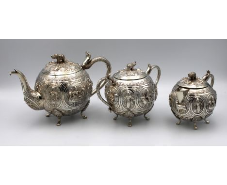 An Indian silver (white metal) three piece bachelor's tea service with raised decoration of Indian deities, elephant finials 