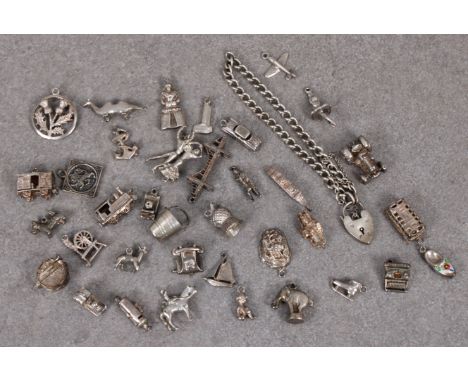 A collection of thirty six (36) silver charms with silver chain and padlock, to include tractor, train, car, plane, elephant,