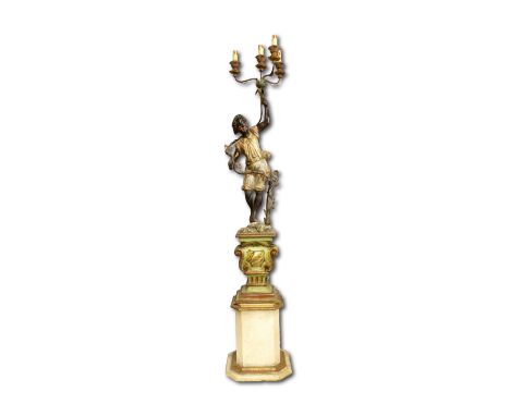 the figure holding a torch with four gilt metal candelabra above, on a scrolling architectural base, 178cm high on separate p