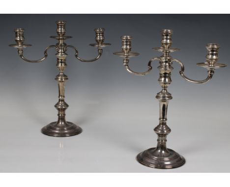 A pair of Elizabeth II silver weighted twin branch candelabra, William Comyns &amp; Sons Ltd, London, 1957, of typical knoppe