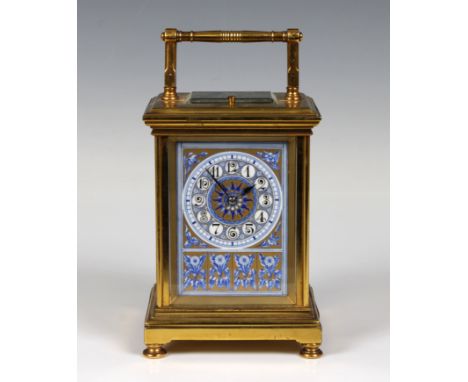 A brass cased carriage clock with porcelain panels, the circular ceramic dial with Arabic numerals and floral decoration, the