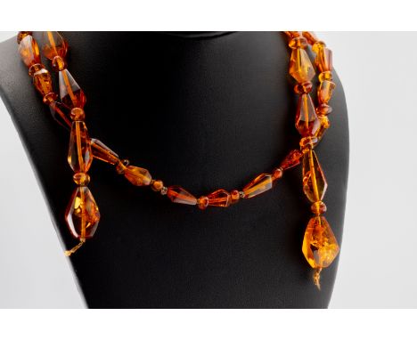 A vintage long amber faceted tear drop shaped bead necklace, having alternating chips and facets (cord broken), approx weight