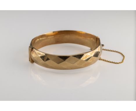 A 9ct gold hinged bangle bracelet, faceted design, inner circumference approximately 17cm, Birmingham 1963, box clasp and saf