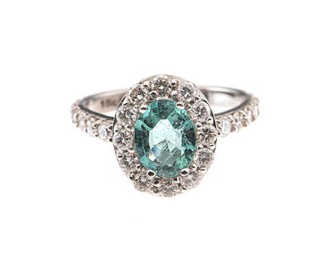 AN EMERALD AND DIAMOND RING centred with an oval mixed-cut emerald weighing approximately 1.10cts, the conforming surround an