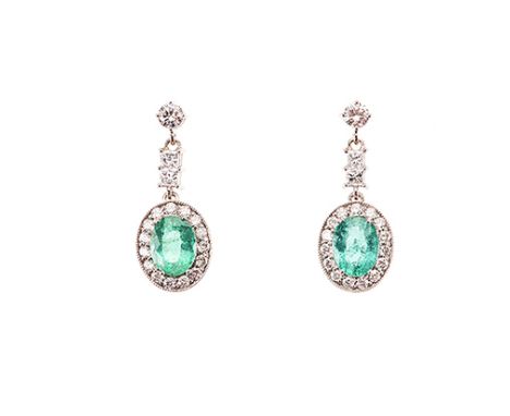 A PAIR OF EMERALD AND DIAMOND PENDANT EARRINGS each surmount claw-set with a round brilliant-cut diamond, suspending two prin