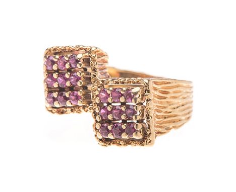 A RUBY RING the textured band terminating in two square forms, embellished with claw-set circular rubies, acid tested as 18ct