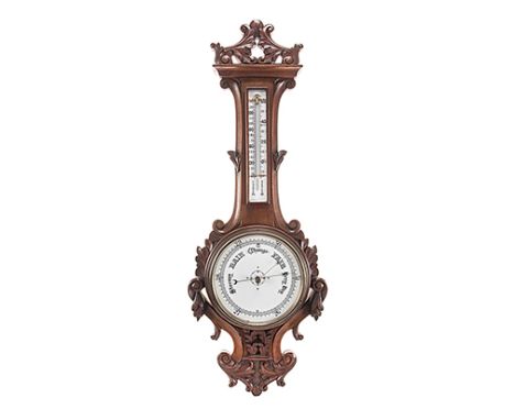 AN OAK ANEROID BAROMETER WITH THERMOMETER, EARLY 20TH CENTURY the carved  oak base with floral terminations to the top, middl