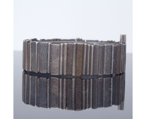 A Danish unmarked oxidised silver and copper modernist industrial style hinged bangle, band width 18.4mm, internal diameter 5