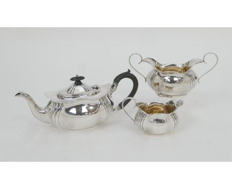 Edwardian silver three piece tea service, Sheffield 1905, comprising an ogee bombe form teapot with ebony finial and handle, 