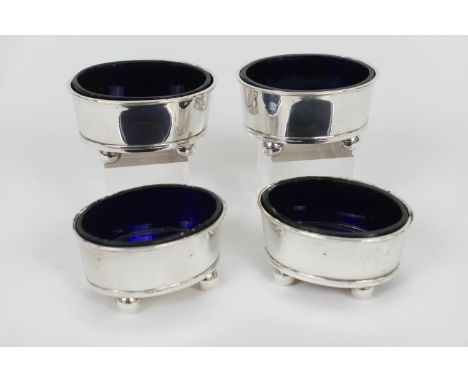 Two pairs of Irish silver table salts, maker R W, Dublin 1947/1950, of good gauge, oval form raised on ball feet, each with b