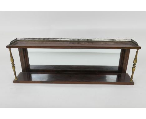 Late Regency rosewood mirrored wall shelf, having a brass galleried top, two lacquered brass columns over a lower shelf, widt