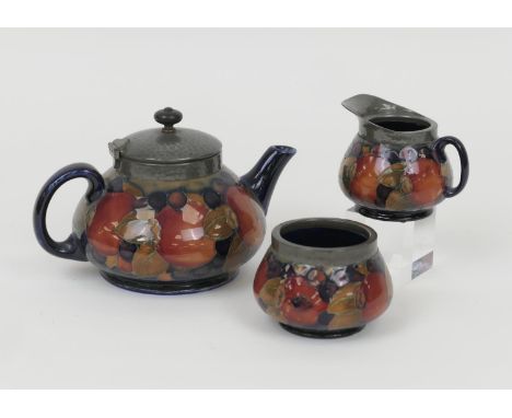 William Moorcroft Pomegranate three piece tea service, comprising teapot with hammered pewter mounts and lid, sugar basin and