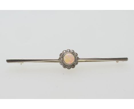 Edwardian opal and diamond bar brooch, in 15ct gold, the central cabochon opal in a millegrain setting bordered with tiny rou