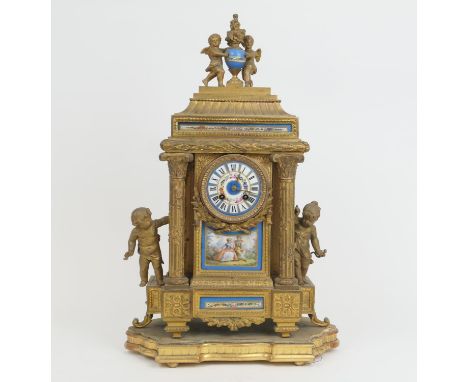 French gilt ormolu mantel clock, late 19th Century, surmounted with cherubs holding a flaming urn, over two columns flanking 