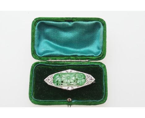 Art Deco carved jade and diamond brooch in 18ct gold and platinum, lozenge shape centred with a jade pierced with flowerheads