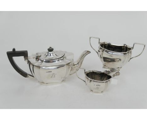 George V silver three piece tea service, Sheffield 1917, comprising a fluted canted teapot, with ebony handle and finial, sug