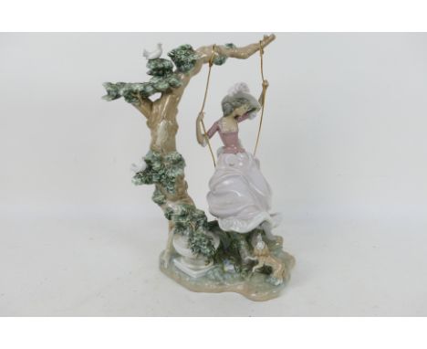 Lladro - A large Lladro figure entitled Swinging # 9163 depicting a young lady on a swing with a dog at her feet, approximate