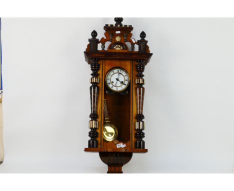 A Vienna style wall clock, the case with turned decoration, glazed door, surmounted by decorative carved pediment, 5.5" two-p