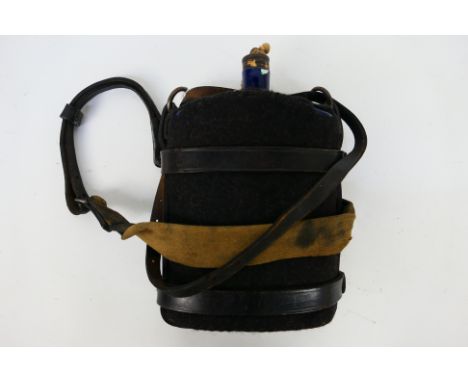 A World War One British army blue enamel water bottle, the leather holster dated 1918.
