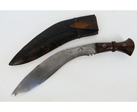 A Gurkha kukri knife, dated 1916, turned wooden hilt with metal pommel, housed in leather sheath.Note: This lot is not for sa