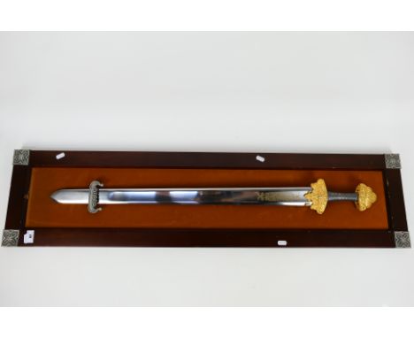 A decorative sword display with viking style sword mounted to display board, approximately 118 cm x 29 cm total size.Note: Th