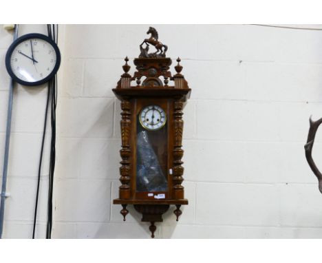 A Vienna style wall clock, the case with turned decoration, glazed door, surmounted by decorative carved horse pediment, two-