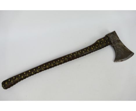 A vintage French axe, the head marked Peugeot Freres, the handle leather bound with stud work, approximately 80 cm (l).Note: 