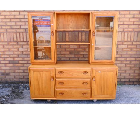 An Ercol Windsor sideboard / display cabinet, the upper part with twin glazed doors either side of an open shelving section, 