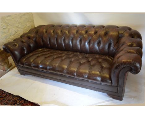 A Brown Leather Upholstered Three Seater Chesterfield Sofa with a Button Upholstered Back and Seat with scroll arms, 218 cms 