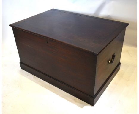 A 19th Century Mahogany Trunk with brass end handles raised upon a plinth, 88 cms wide