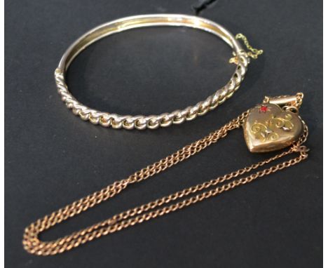 A 9ct. Gold Locket in the form of a heart set with a ruby together with a 9ct. gold linked chain and a yellow metal bracelet,