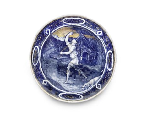 A late 16th / early 17th century Limoges enamel plate depicting a huntsman and a houndpainted en-grisaille on a blue ground w