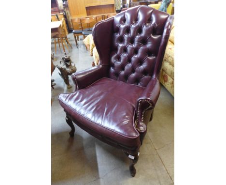 A Regency style mahogany and burgundy leather button back wingback armchair 
