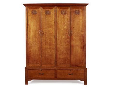 ARTHUR W. SIMPSON OF KENDAL (1857-1922)  ARTS & CRAFTS CARVED OAK WARDROBE, CIRCA 1910   the projecting moulded cornice above