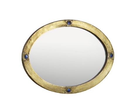 MANNER OF LIBERTY & CO.  ENAMELLED AND BRASS WALL MIRROR, CIRCA 1900   of oval outline, the hammered surface inset with four 