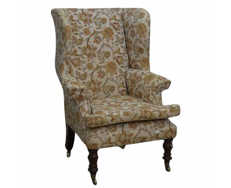 A Victorian mahogany wing Armchair,&nbsp;the upholstered back with lugged sides and outscrolled arms, raised on ring-turned f