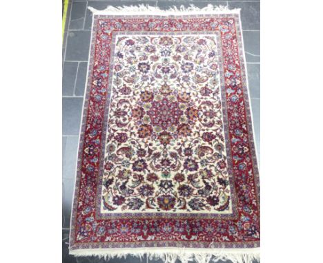 Tribal Rugs; a Persian Isfahan rug,&nbsp;finely knotted wool pile on cotton base, cream ground within a red border, the whole