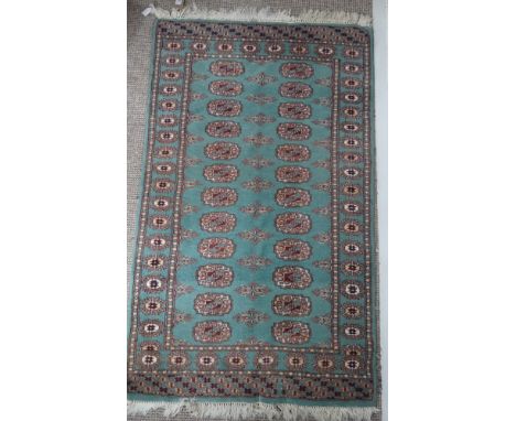 Tribal Rugs: a green ground Bokhara rug, wool pile on a cotton base, good condition, 140cm x 79cm.