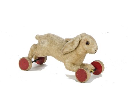 A late 1930s Steiff running rabbit on eccentric wheels, with light brown wool/mohair plush, brown and black glass eyes, black