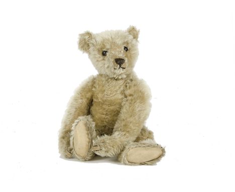 An early Steiff Teddy Bear, circa 1910, with blonde mohair, black boot eyes, pronounced clipped muzzle, black stitched nose, 