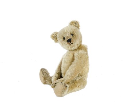 An early Steiff centre - seam Teddy Bear, circa 1910, with blonde mohair, black boot button eyes, pronounced clipped muzzle, 