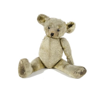 An unusual British Teddy Bear, 1920s, with blonde mohair, oily clear and black glass eyes with remains of brown painted backs