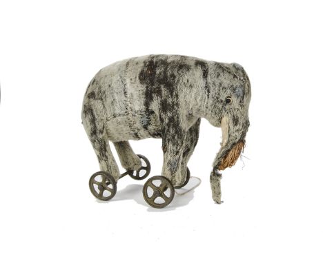 An early elephant on wheels, 1910-20s, with grey mohair, black boot button eyes with white felt discs behind, felt tusks and 