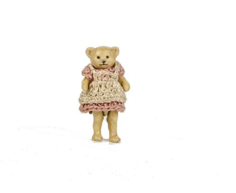 A Hertwig all - bisque girl Teddy Bear, 1910-20s, with pin - joints and pink crochet dress - 1¾in. (4.5cm.) high