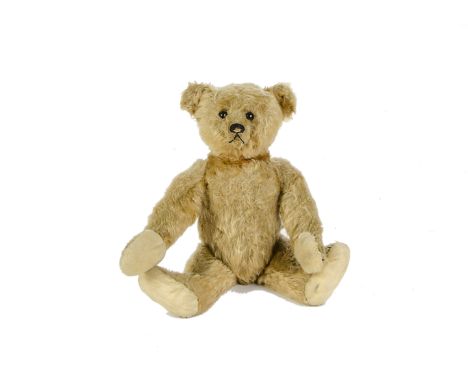 An early Steiff Teddy Bear, circa 1910, with golden mohair, black boot button eyes, pronounced clipped muzzle, black stitched