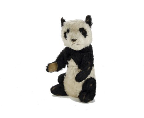 A Chiltern Panda, 1930s, with black and white mohair, orange and black glass eyes, fixed neck, jointed arm, velvet pads, tail
